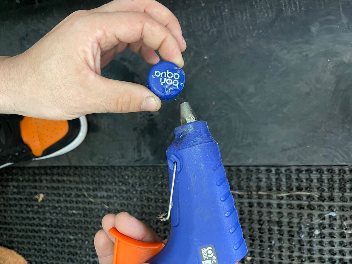 Наносим горячий термоклей на пробку бутылки.