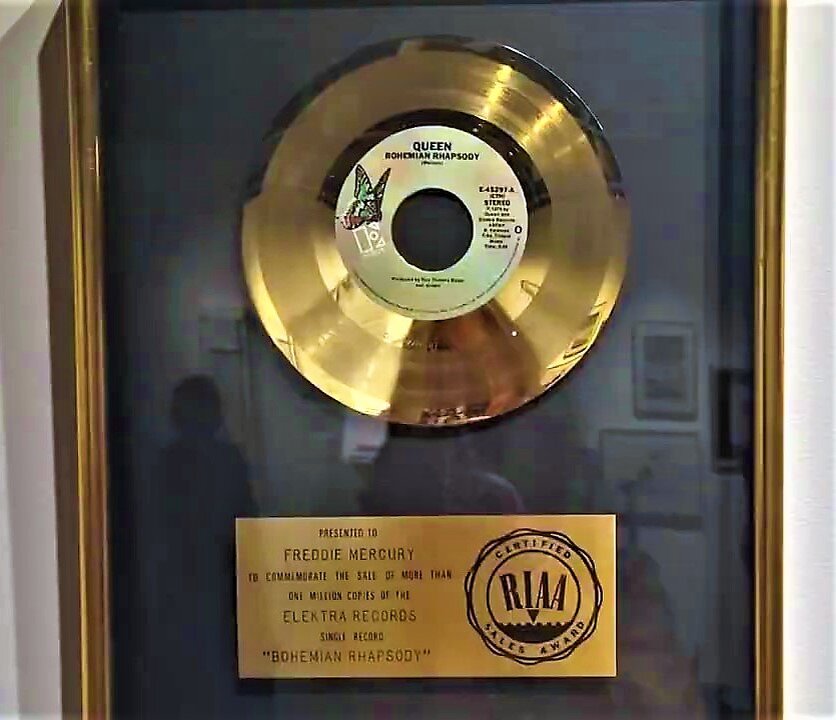 Фото с выставки. Вероятно, это платиновый диск (сингл) Queen "Богемская рапсодия" (написано, что продано более 1 млн. копий. Презентовано Фредди Меркьюри.
