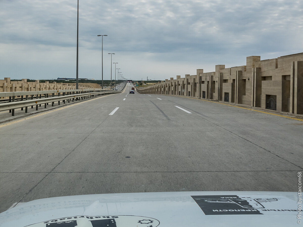 Эти монументальные заборы по сторонам трассы отделяю ее от пустырей, нефтепромыслов и лачуг местных бедняков. 