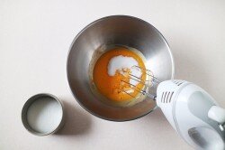 Разбейте яйца и отделите белки от желтков. Поместите желтки в миску и добавьте сахар. 