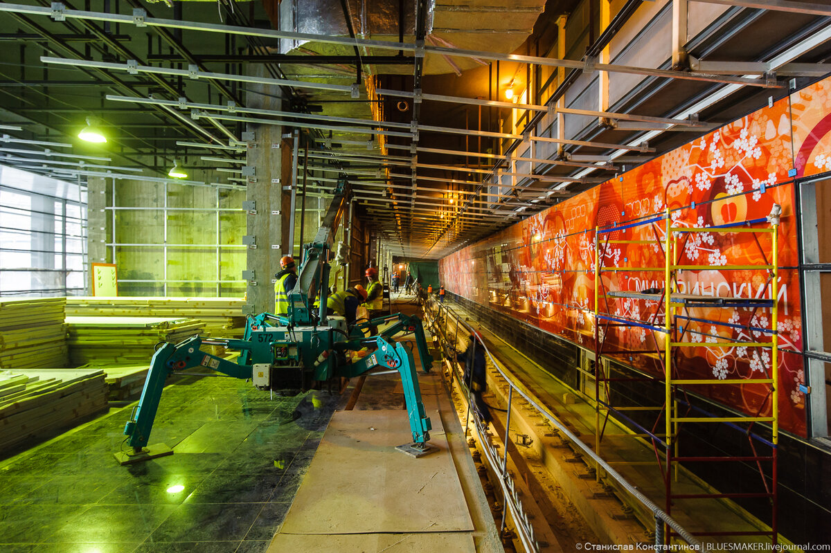 
В прошлый раз мы были на стройплощадке будущей станции "Мичуринский проспект" почти год назад, весной прошлого года. С того момента тут естественно произошли большие изменения, однако работы еще далеки до завершения. Зато уже сейчас весь этот огромный комплекс сооружений, в который включены два вестибюля и эпических размеров мост через Мичуринский проспект уже приобретает те формы, которые архитекторы заложили в своем проекте. Оформление станции перекликается с соседними ст.м. "Минская", "Ломоносовский проспект", Раменки" и "Очаково", вся эта пятерка спроектирована в одном, едином архитектурном стиле. Но "Мичуринский проспект" будет на этом участке самой впечатляющей станцией. Хотя бы по тому, что почти вся она будет находиться над землей. И оба вестибюля и переход между ними будут наземными. Более того, из-за особенностей рельефа тут на пересечении Мичуринского проспекта с улицей Удальцова даже поезд выглядывает из под земли и из его окон можно будет наблюдать "панорамный вид на долину реки Раменка", как пишут на сайте стройкомплекса. Поглядим как там обстоят дела. Сегодня заглянем в первый вестибюль и на платформу.