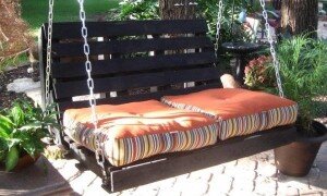 Поддон подойдет для качелей. Правда, понадобится соорудить крепкую перекладину. К ней паллет крепят толстой веревкой или цепями. Поверх можно положить мягкую подушку. При желании сооружается и спинка.