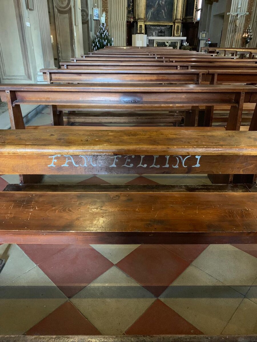 Скамья в церкви с надписью "семья Феллини"
