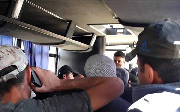 Задержанные мигранты в полицейском автобусе. Фото со страницы Каримджона Ёрова в Facebook
