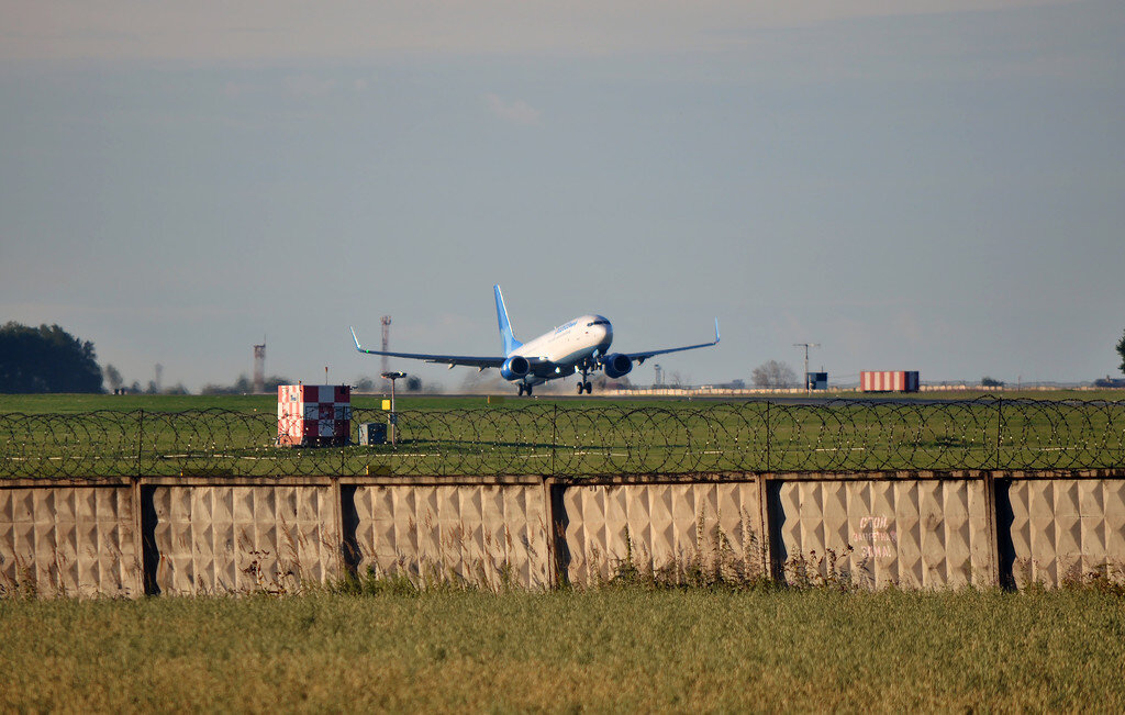  По возвращении из Питера до поезда в Омск было достаточно времени. Ранним утром, прилетев "Победой", получил багаж. на привокзальной площади меня встретил alexx72 (которому и выражаю за это благодарность. а также консультации относительно перелета из Тюмени "Победой") и мы отправились к торцу полосы... Пару слов об аэропорте. "Рощино" располагется в 13 км к западу от Тюмени, эксплуатант аэропорта — ОАО «Новапорт». Является базовым аэропортом для авиакомпаний ЮТэйр и Ямал. Имеет статус аэропорта федерального значения. Аэродром допущен к приему следующих ВС: Ан-124 (для осуществления посадки/взлета необходим единоразовый спец.допуск), Ту-134, Ту-154, Ту-204, Ту-214, Ил-76, Sukhoi Superjet 100-95, Boeing 737, Boeing 757, Boeing 767, самолеты семейства Airbus A320, ATR 72, Bombardier Canadair Regional Jet (CRJ) и все более лёгкие, а также вертолёты всех типов. Технически аэродром может осуществлять прием таких ВС, как Boeing 777, Boeing 747, Airbus A330, Airbus A340, однако, в настоящий момент в паспорте аэродрома данные воздушные суда не представлены и посадка/взлет в «Рощино» для таких ВС возможны только по временному спец.допуску. 

