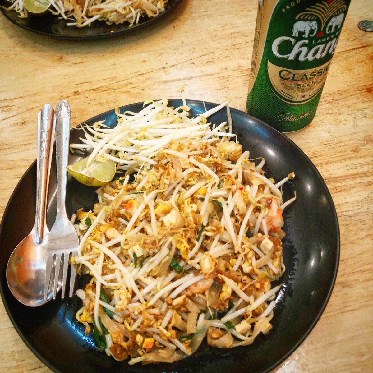 Наверное, многие узнали на фото самое известное тайское блюдо "Пад Тай". Его подают как в ресторанах, так и в любых забегаловках. Представляет собой рисовую лапшу, обжаренную в соусе, курица или морепродукты, тофу, пророщенные ростки, арахис и специи. Одно из моих любимейших блюд в Азии.