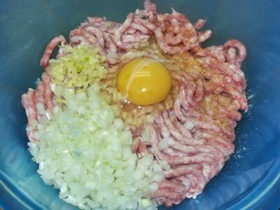 В фарш кладём мелко нарезанный лук, измельчённый чеснок, яйцо и сванскую соль. Хорошо перемешиваем, накрываем плёнкой и убираем на время в холодильник.