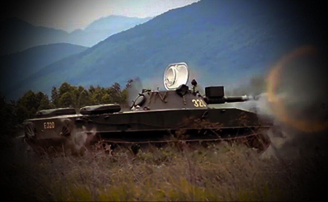 Танк ПТ-76 ведет огонь из танковой пушки