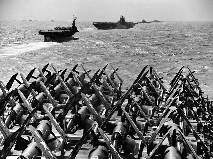 10 февраля 1945 года - корабли тактической группы 58.3 выходят из атолла Улити в море. Снимок сделан с авианосца CV-17 "Банкер Хилл", впереди - авианосцы CVL-25 "Каупенс" и CV-9 "Эссекс" (флагманский корабль TG 58.3), далее крейсера CL-65 "Пасадена" и CL-90 "Астория".