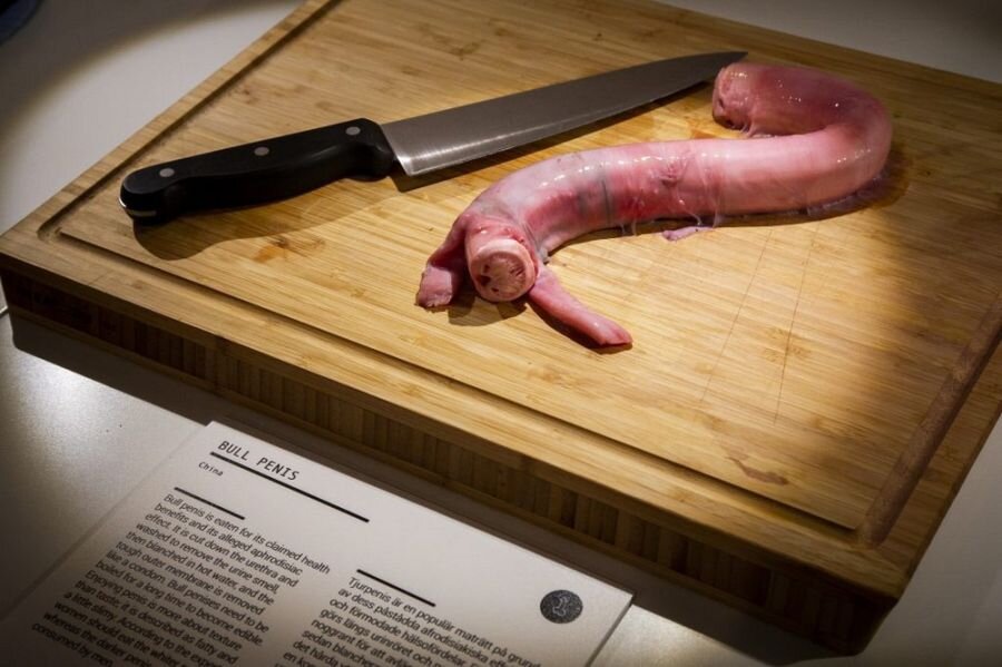 Сырой бычий пенис на разделочной доске