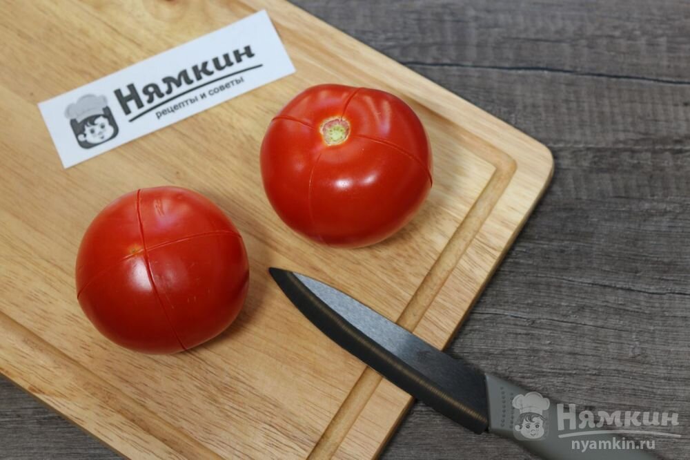 2. Во вторую очередь необходимо заняться помидорами. С них нужно снять кожицу, чтобы она не мешала в соусе. Для этого острым ножом нужно сделать несколько неглубоких надрезов поперек всего помидора. Такие помидоры нужно выложить в миску, тарелку, кастрюлю, что угодно, неважно,