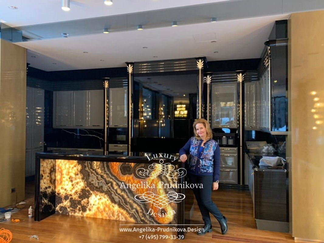 На фото: Анжелика Прудникова на фоне черной кухни с дизайнерской барной стойкой
