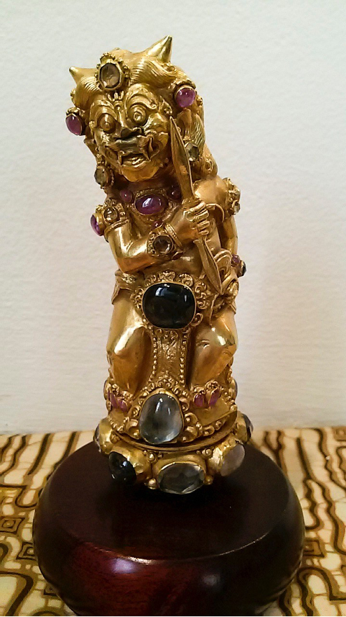 
Рис. 2: Потрясающая рукоять, сделанная из золота,
украшенная драгоценными и полудрагоценными камнями:
она, скорее всего, изображает Равану (Рахвану), носящего
оружие, похожее на двуручный индийский кинжал халади.
Бали.