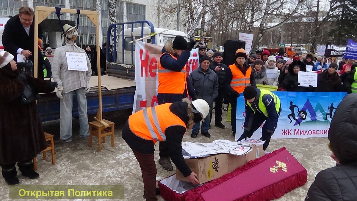 дольщики укладывают тело символического застройщика в гроб и заколачивают гроб огромными гвоздями.