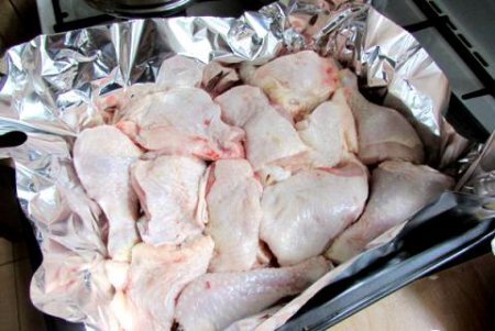 Шаг 1 Куриные голени и бедра хорошо моем , выкладываем на противень, застеленный фольгой.