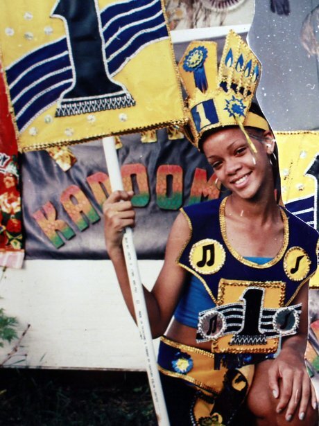 Улыбающаяся Рианна позирует с флагом на карнавале в Барбадосе.