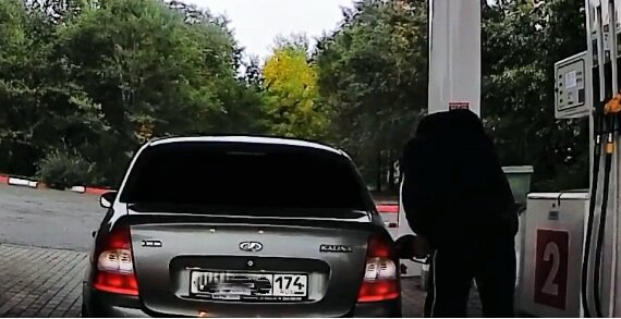 Мужик пытается выкачать побольше бензина с колонки, орудуя ручкой заправочного пистолета как насосом