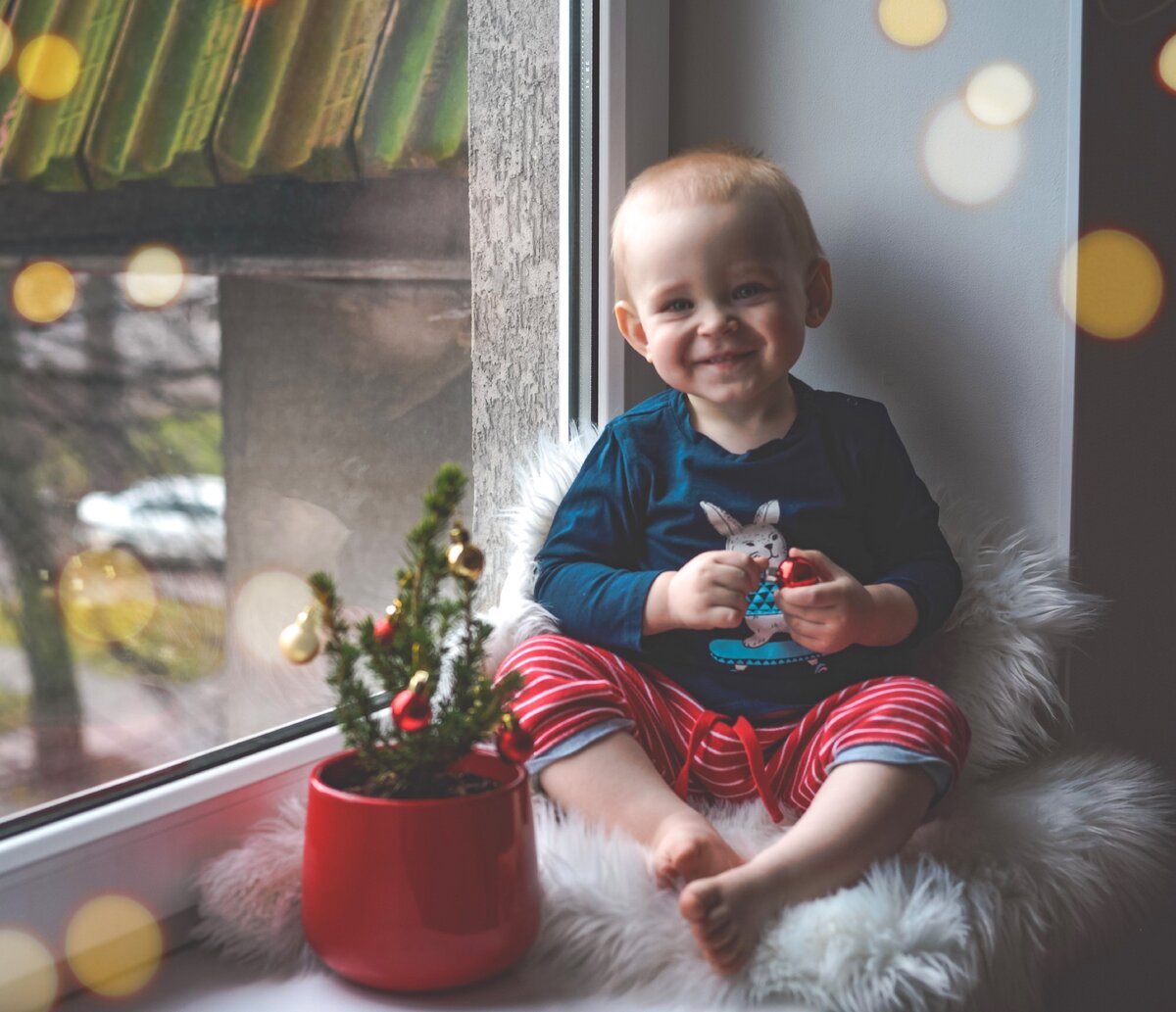 Довольный сын в сотый раз "разряжает" и наряжает обратно нашу ёлочку.