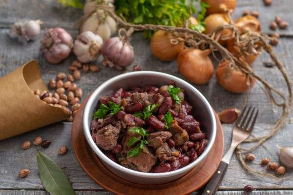  Фасоль с мясом и копченым беконом — пряное рагу с красным вином, которое я советую приготовить к воскресному обеду. Понадобится некоторое время на подготовку продуктов — маринование мяса и вымачивание фасоли. Особенных трудовых затрат эти действия не отнимут, но процесс длится от 4-х до 6 часов. Поэтому удобно замариновать мясо и замочить бобовые вечером, а с утра приготовить рагу.