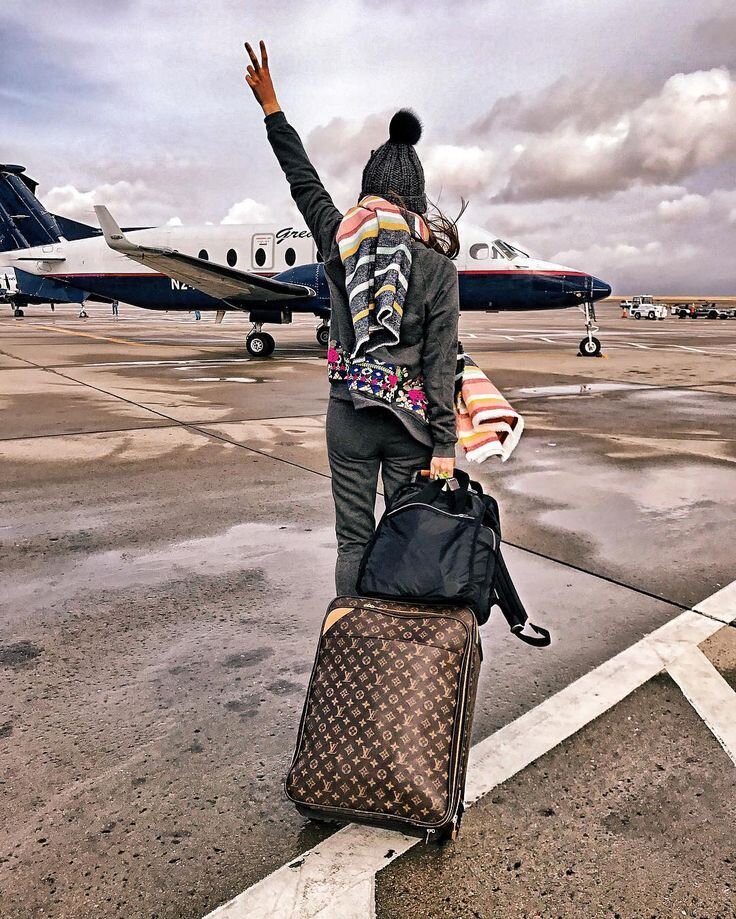 Девушка с чемоданами у аэропорта