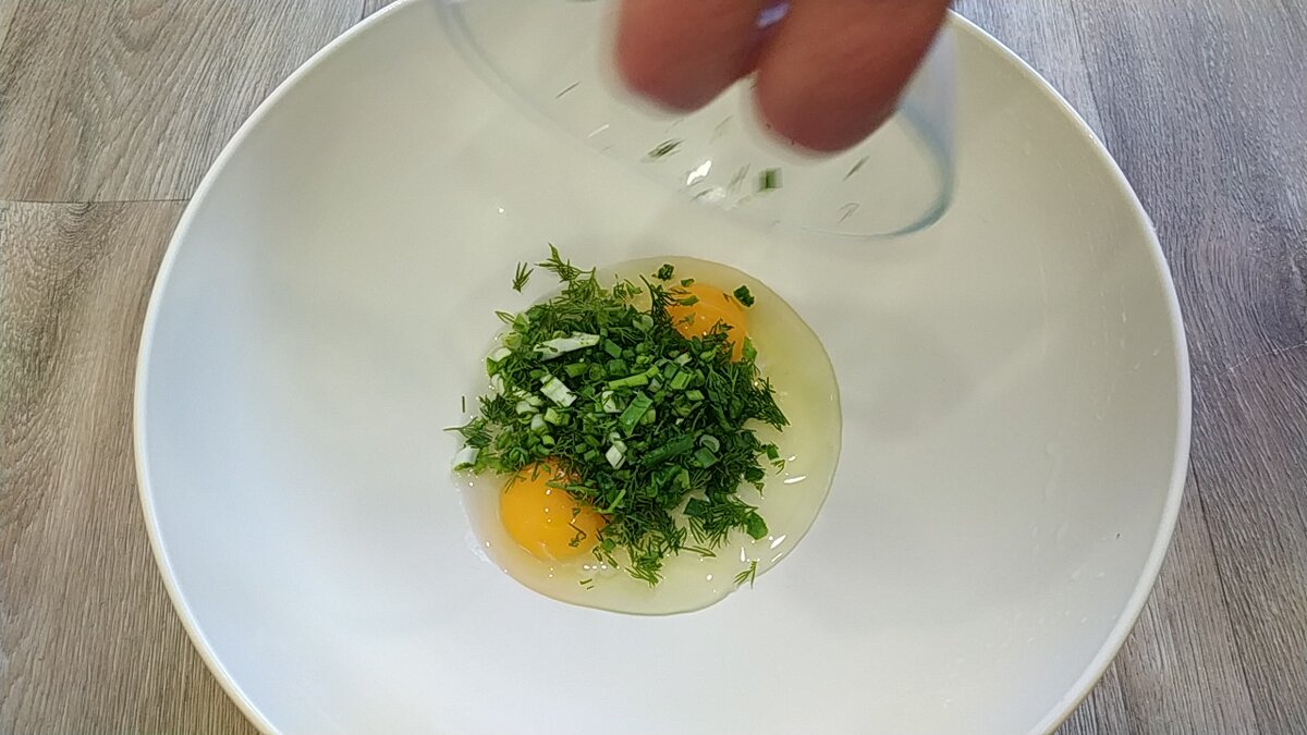 В миску разбить яйца,добавить мелко нарезанный укроп и зеленый лук