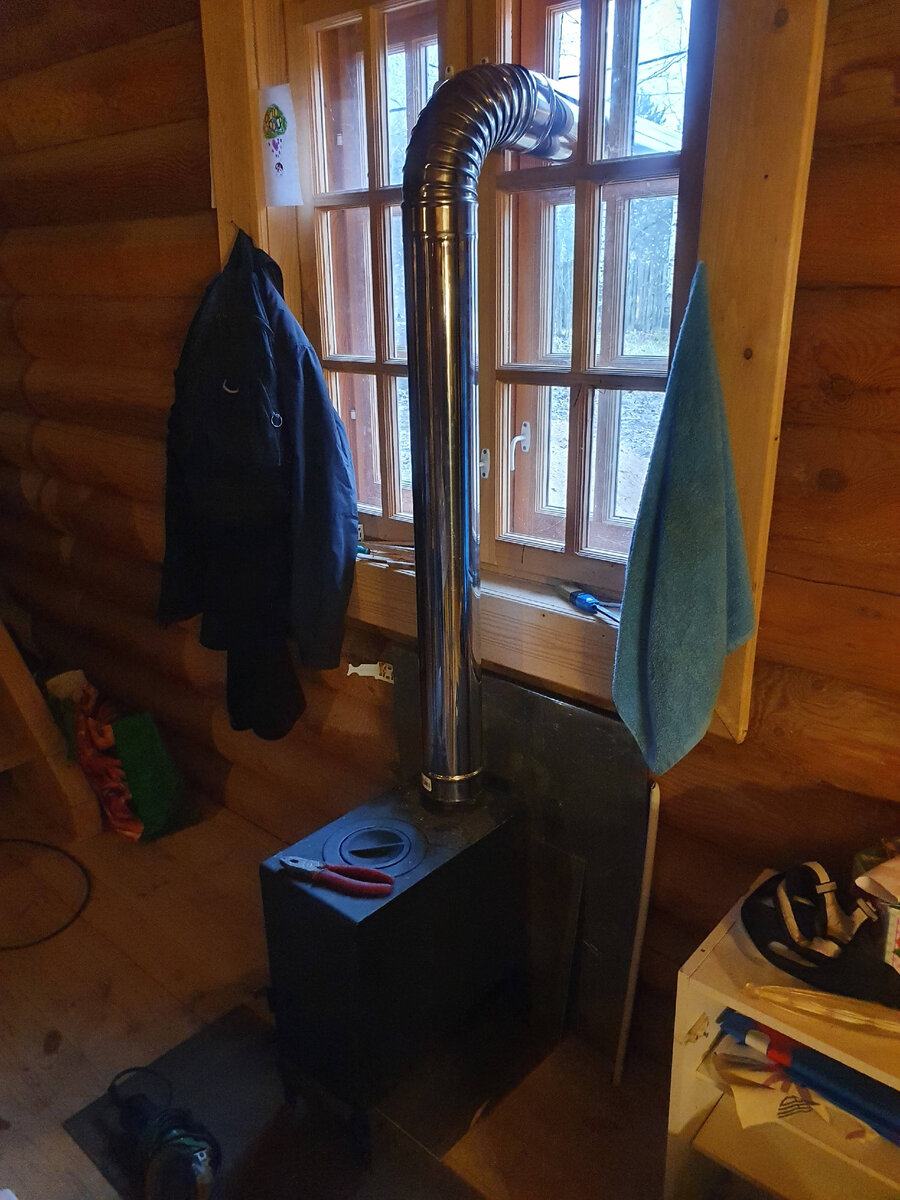 Вот так мы поставили печку в доме. Дымоход собрали только частичнопока, только для того, чт бы понять на какой высоте он выходит на улицу. Это решение временное, потому просто вывели в окно вынув стёкла.
