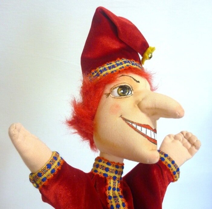 Длинный нос, красная рубаха, колпак с кисточкой! Прообраз нашего Буратино не Пиноккио, а Петрушка! И оп одежде, и по внешнему виду, и по характеру. Источник Яндекс Картинки.