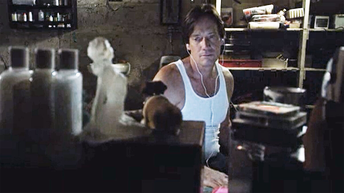 Кадр из фильма "Юлия Х". Маньяк (Кевин Сорбо) следит за похищенной девушкой, слушая музыку.