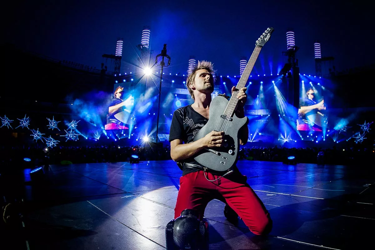 Певец играет на гитаре. Гитарист группы Muse. Группа Muse на сцене. Басист Muse. Концерт Мьюз 2019.