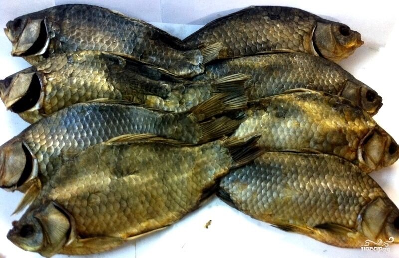 Как приготовить вяленого карася я знала, наверное, с глубокого детства. Мой дядя каждые выходные уходил на рыбалку и возвращался всегда с отличным уловом, поэтому, я как сейчас помню, эти ряды рыбы, которые висели у нас на балконе. Теперь, к сожалению, он занимается заготовкой рыбы не так часто, зато я иногда балую себя, особенно летом. И сейчас я хочу рассказать вам самый простой рецепт вяленого карася в домашних условиях. 
Ингридиенты:
Карась свежий: 1 Килограмм,
Соль: 200 Грамм
Приготовление:
В ингредиентах я указывала количество соли на 1 килограмм рыбы. Соответственно если рыбы более 1 килограмма, то соли надо брать тоже больше.
Для начала нам необходимо выпотрошить рыбу, мы извлекаем все внутренности, кроме икры, если таковая имеется.
Когда от внутренностей мы избавились, тщательно промываем карасей под холодной водой.
Затем выкладываем рыбу рядами в эмалированную посуду и каждый ряд посыпаем солью, оставляем на трое суток. По истечении времени достаем рыбу, промываем под холодной водой и на 2 часа оставляем стекать в дуршлаге. Когда вода стечет, вывешиваем в сухом месте и вялим в естественных условиях.