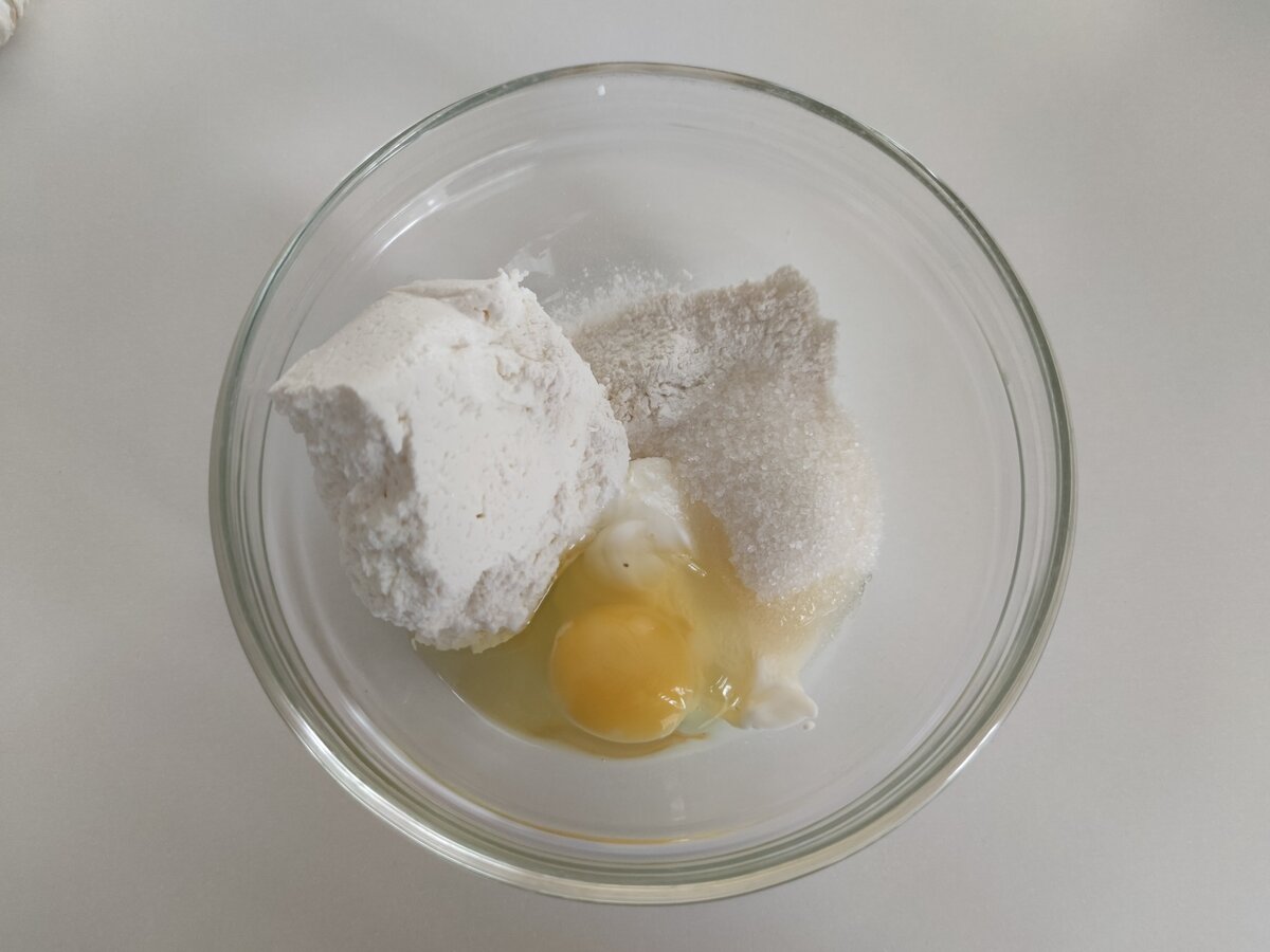 Отправляем в чашку творог, яйцо, сметану, муку и сахар. Перепешиваем