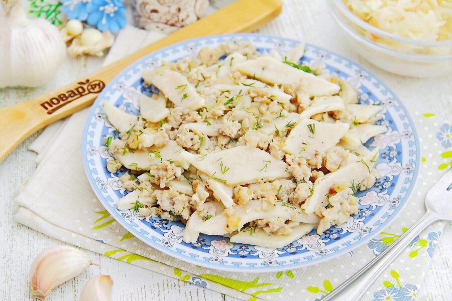 Ленивые пельмени. Нежное вареное тесто, мясо и зелень всегда отлично смакует. Добавьте сметаны, измельченного острого перца или жареного лучка со шкварками и получите новое блюдо. Кстати, полоски теста можно заготовить впрок – заморозить или засушить. Это очень удобно и просто! Ингредиенты для теста: 500 г муки; яйцо; 1 ст. л. растительного масла; 200 мл воды; щепотка соли. Ингредиенты для мясной начинки: луковица; 3 ст. л. растительного масла; 300 г фарша (свинина); соль, перец, специи. Для теста в миске взбейте венчиком яйцо, воду, масло, соль. Затем частями введите муку и замесите мягкое тесто. Раскатайте его тонко на присыпанном мукой столе и порежьте ромбиками или полосками. Для ужина возьмите грамм 200, остальное засушите в духовке при температуре 100 градусов (до плотного состояния). Либо выложите в один слой на поддон, заморозьте в морозилке, а затем сложите в специальный пакет. Мясную начинку готовим так, В сковороде на масле обжариваем нарезанный мелким кубиком лук, затем выкладываем фарш и жарим на среднем огне, разбивая комочки лопаточкой. Солим, перчим, добавляем любимые мясные специи.  Заготовки из теста бросьте в кипящую подсоленную воду и варите несколько минут, пока не всплывут и станут мягкими, затем откиньте на дуршлаг. Готовое вареное тесто бросьте в сковороду к мясу и перемешайте. Заправьте блюдо зеленью и подавайте, приятного!