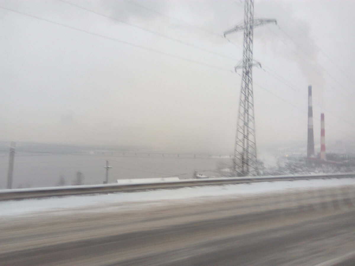 Дорога в Мурманск вдоль берега Колы. Вдали виднеется мост через реку.