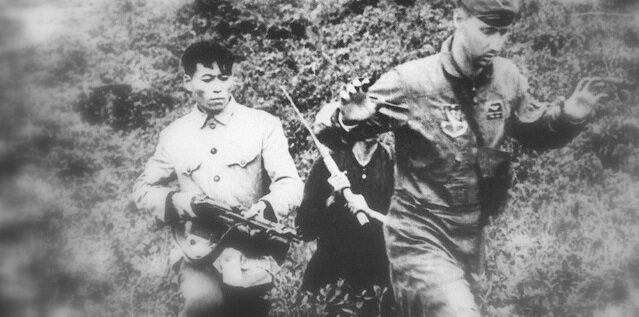 Виетнамски войници карат пленен американски войник във Виетнамската война.