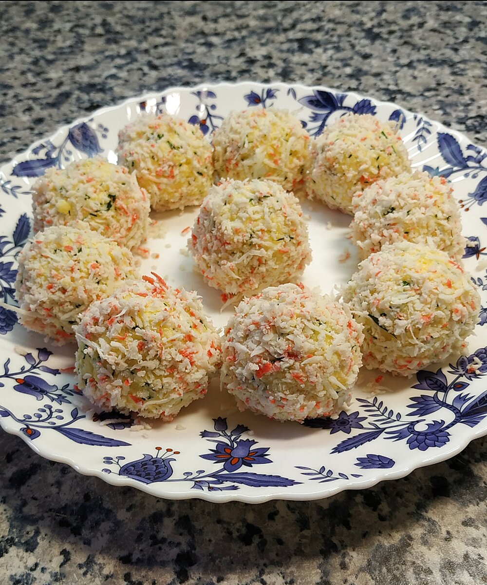 Ингредиенты на 10 шт.: крабовые палочки - 80 гр.
сыр (Эдам) - 200 гр.
яйца - 2 шт.
чеснок - 2 зубчика
майонез - 60 гр.
маслины без косточек - 10 шт.
укроп
соль по вкусу

1. Крабовые палочки подморозить и натереть на мелкой терке.
2. Сыр, яйца и чеснок натереть на мелкой терке, добавить измельченный укроп и майонез. Добавить соль при необходимости. Тщательно перемешать. 
3. Сформировать небольшие шарики, в центр положить маслинку.
4. Сырные шарики обвалять в натертых крабовых палочках.
Убрать в холодильник на несколько часов.