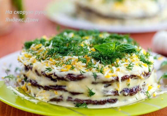 На фото печеночный торт, украшенный зеленью и вареным желтком