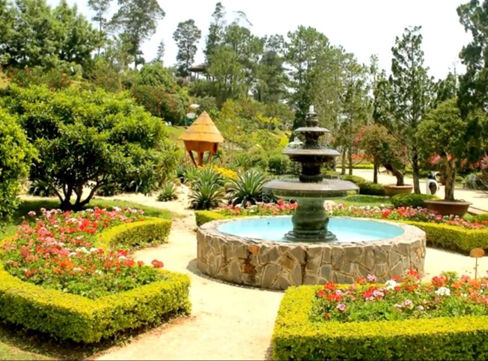 Небольшой фонтанчик в саду цветов