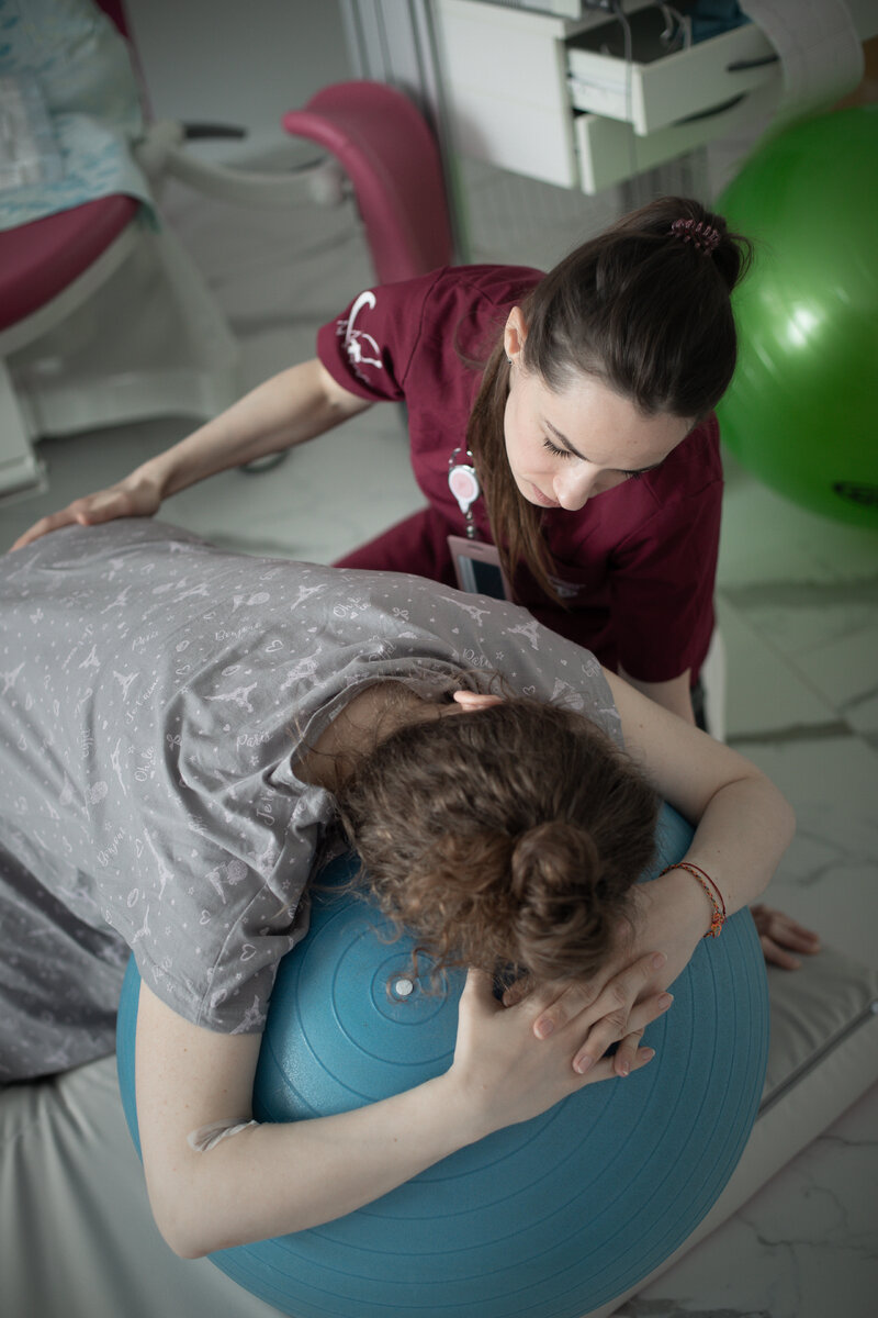 Акушерка Светлана Терс делает массаж пояснице женщине в первом периоде родов 