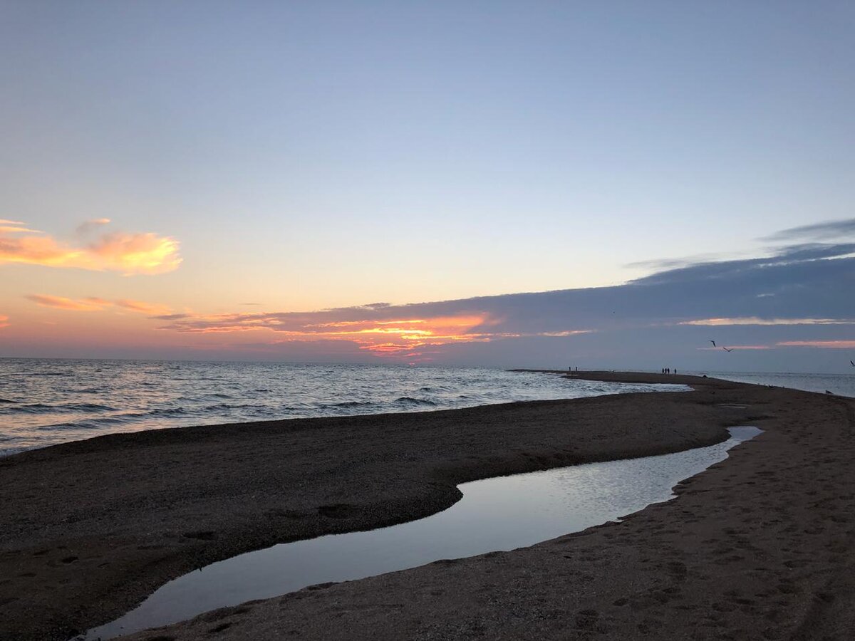 В конце косы видны фигурки людей. Они пришли в конец косы посмотреть закат. Вокруг море, а ты смотришь на заходящее в это море солнце... Восхитительные ощущения. Кстати, провожать солнце на косе приходят не только влюбленные парочки, но даже и компании молодых парней. Воистину красоту любят все.