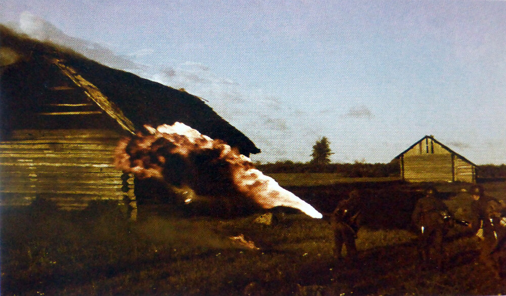 Немецкий огнеметчик поджигает деревянную постройку на оккупированной территории СССР.