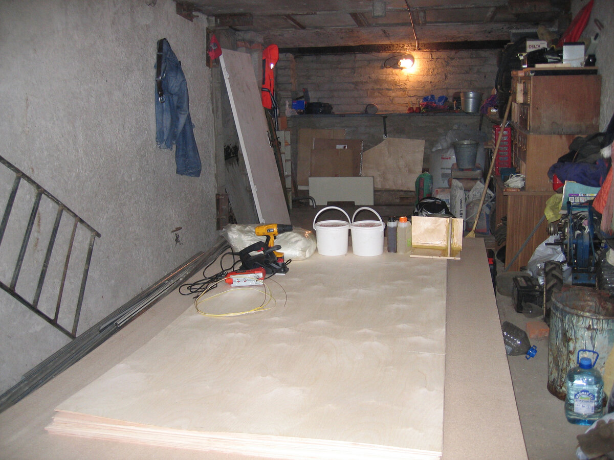 Гараж с рабочим столом и частью материалов.