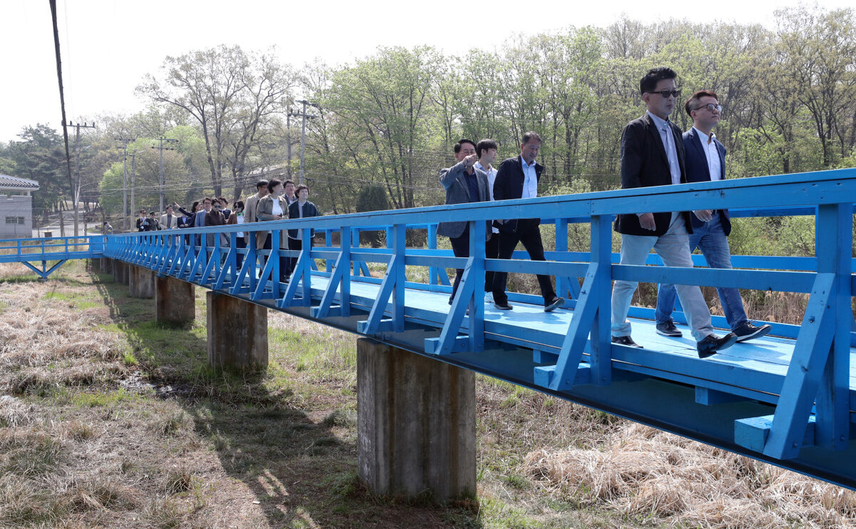 В среду посетители шли по пешеходному мосту в  зоне JSA в демилитаризованной зоне (DMZ). Причем по этому мосту  прогулялись Президент Южной Кореи Мун Чже Ин и лидер Северной Кореи Ким  Чен Ын во время их первого саммита 27 апреля 2018 года. (Yonhap)
