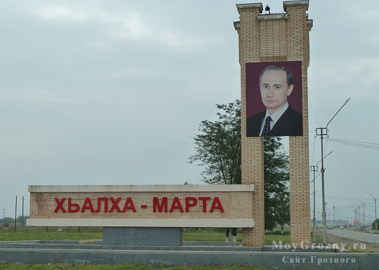 Въезд в Урус-Мартан. Хьалха-Мартан - параллельное используемое местным населением название городка. На портрете - Тот, кто даёт деньги Падишаху.