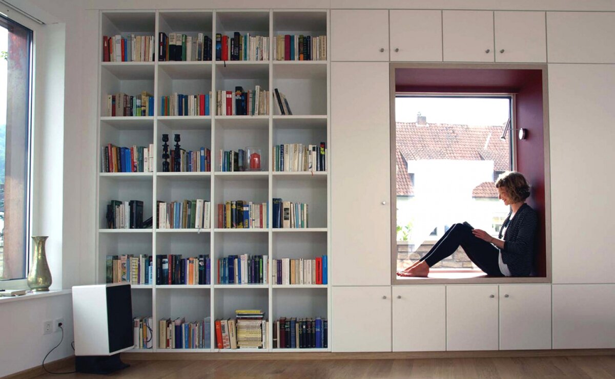 Книжный шкаф в нише. Книжный стеллаж во всю стену. Книжные стеллажи вокруг окна. Стеллаж у окна.