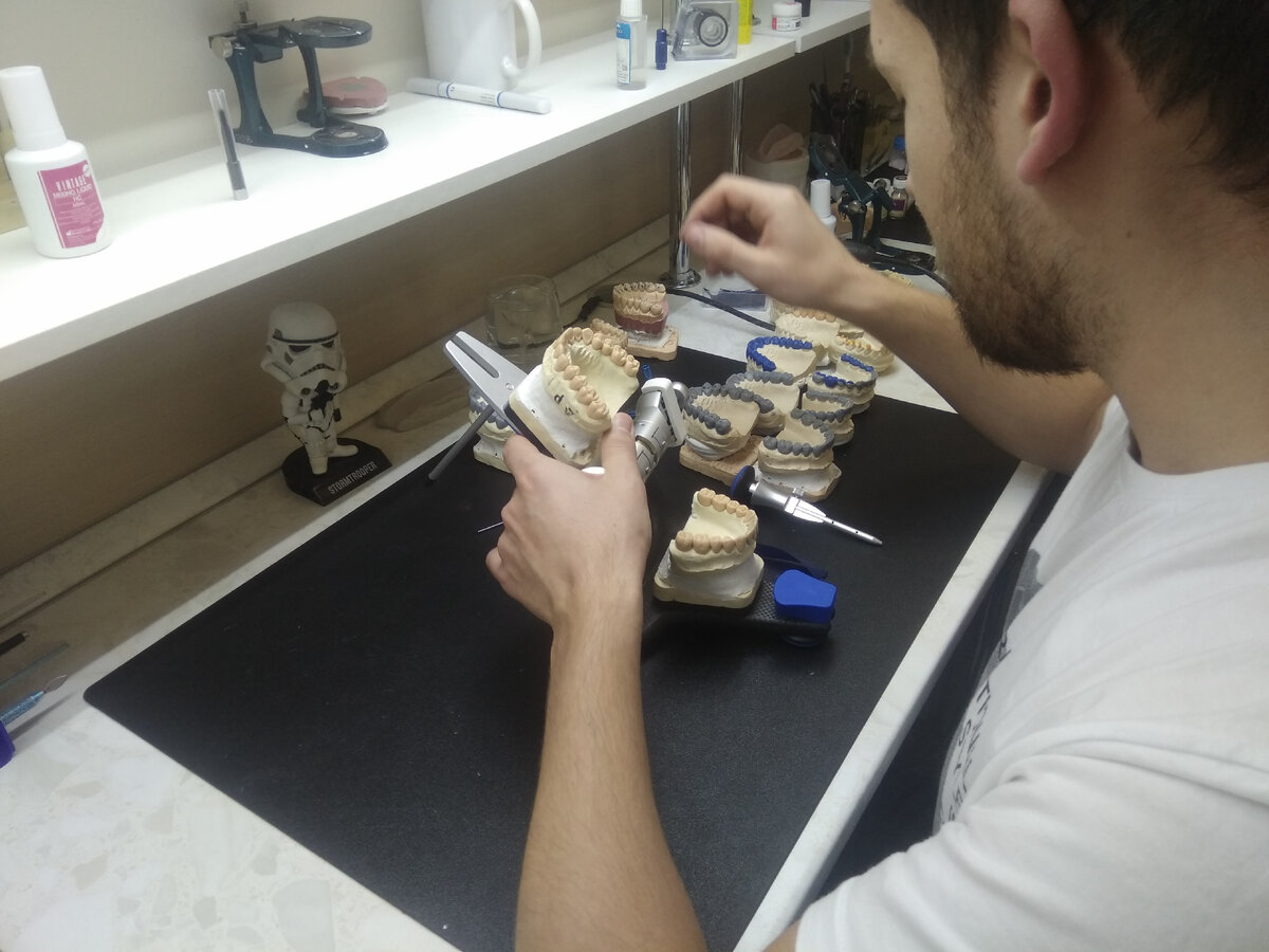 Зубной техник на рабочем месте (оборудованное спец. средствами рабочее место)