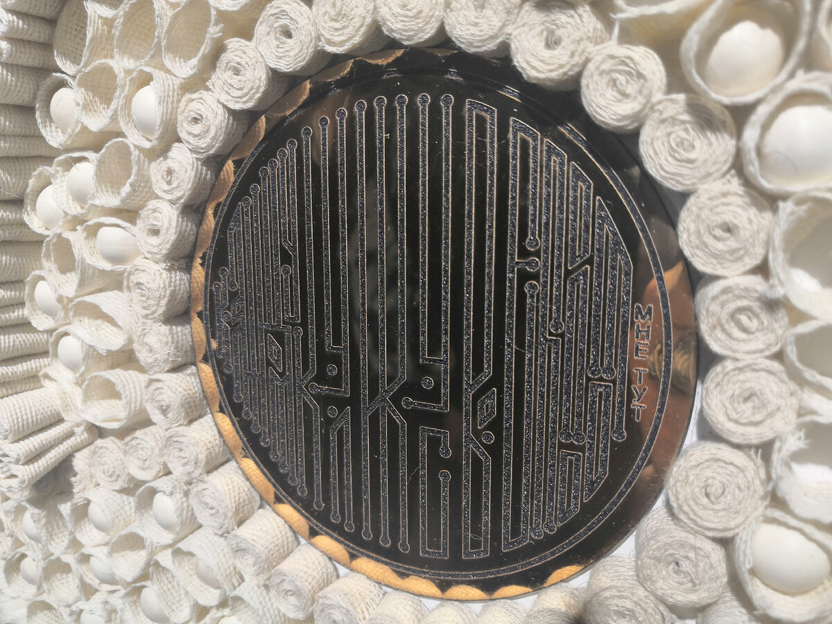 Вавилон. Ксения Ладатко. Неразгаданная загадка края, символ вселенной – Поморский Вавилон в виде текстильной мозайки из натуральных материалов. Зеркальная гладь в центре композиции – текст с поморской пословицей. Буквы – современная стилизация поморской вязи. «Каждому кулику свое болото: мне тут».