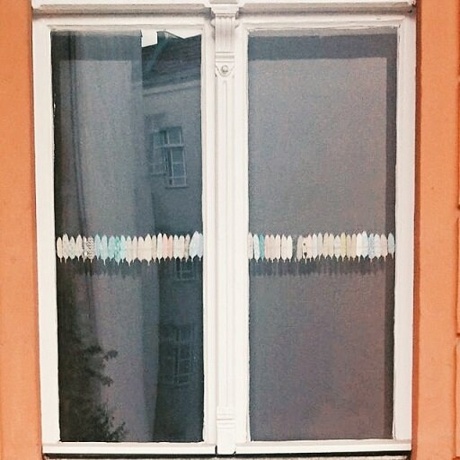 Окошко встречено в Берлине в июне этого года. Вдоль него приклеены крошечные разноцветные перышки. Окошко, которое по-своему глядит в мир. Это ли не волшебство? 