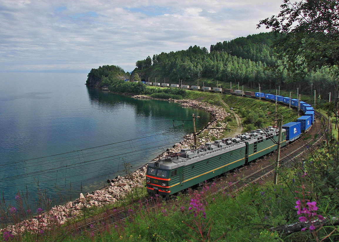 © Sorovas / Wikimedia Commons / CC BY-SA 3.0 (Электровоз с контейнерным составом на перегоне Утулик-Слюдянка. Побережье озера Байкал)