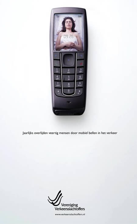 Надпись на плакате гласит: «Каждый год десятки человек умирают из-за разговора по мобильному телефону во время вождения»