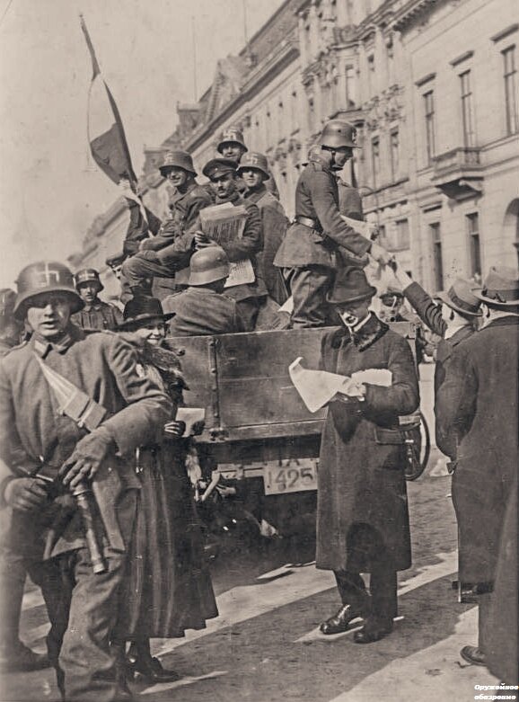 Члены Freikorps Ehrhardt (свободного корпуса) в  шлемах (касках) времен Первой мировой войны с нанесенной от руки свастикой